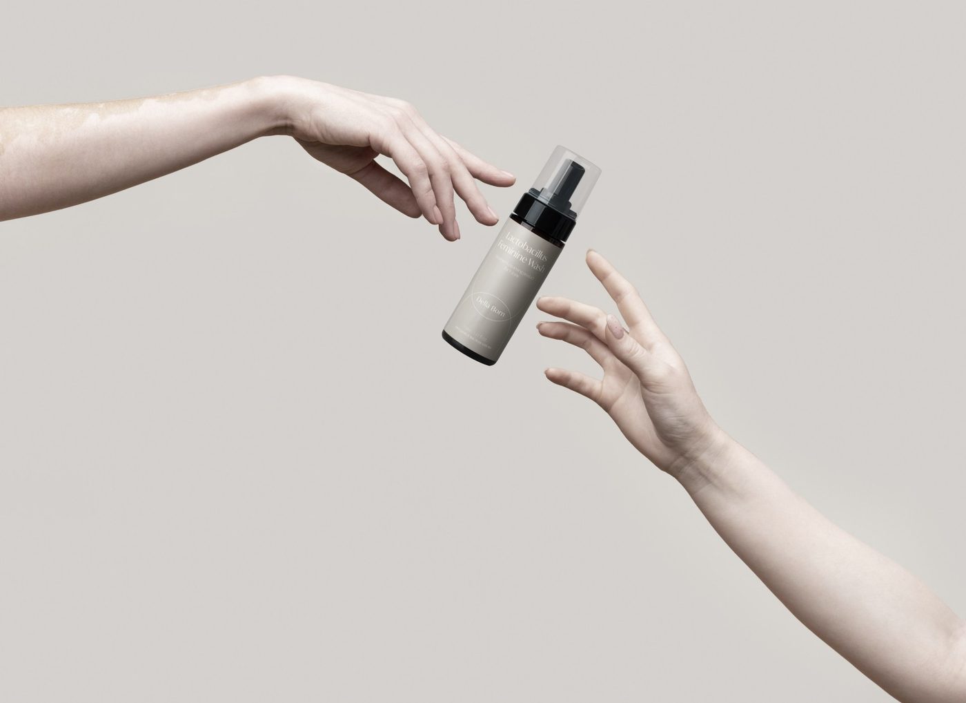 A hand holding the bottle out