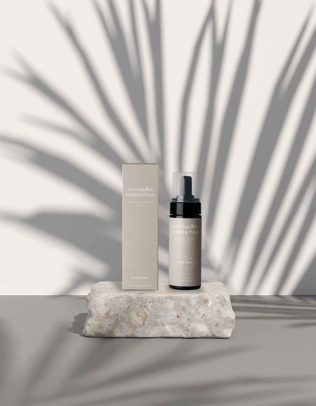 Feminine bottle on stone under a palm shadow