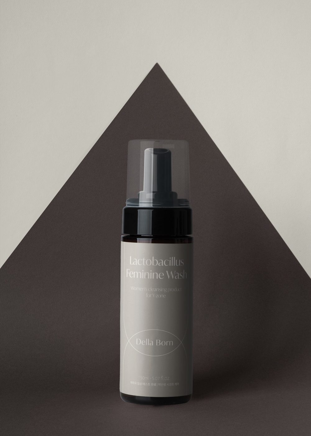 Feminine bottle in front of a dark triangle